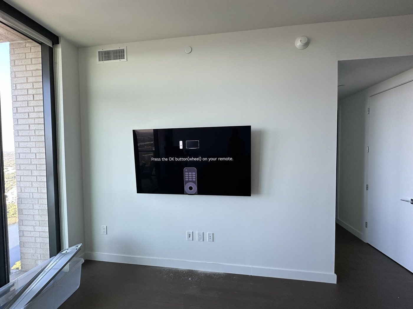 Large LG TV mounted in a downtown Austin high-rise with a lake view