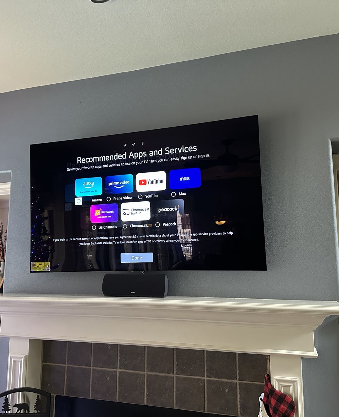 LG TV mounted over a white fireplace mantel